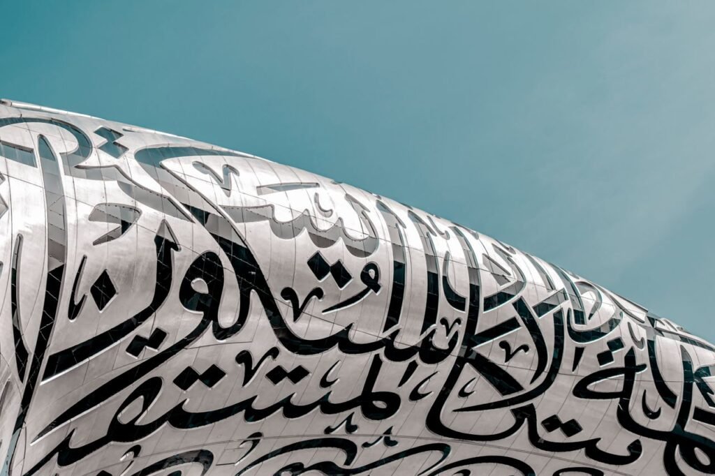 Close-up of Museum of the Future facade in Dubai featuring intricate Arabic calligraphy against a blue sky.
